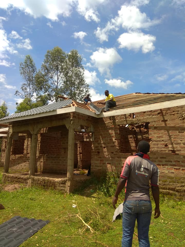 Two men constructing a school house in Kenya from brick