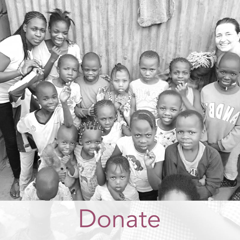 A black and white picture of a group of Kenyan school children standing with their two female teachers